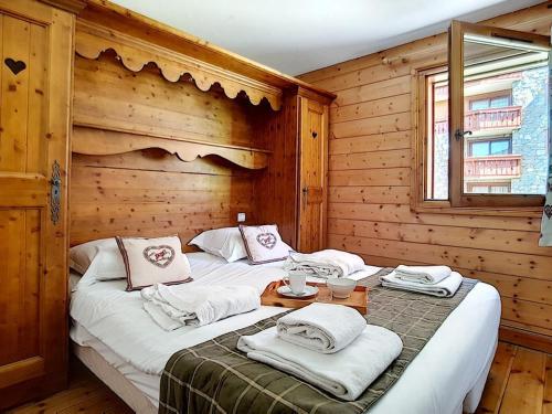 - une chambre avec 2 lits dans une pièce en bois dans l'établissement Appartement 3P avec Balcon, Piscine et Parking · Proche Pistes à Reberty 2000 - FR-1-344-741, aux Menuires