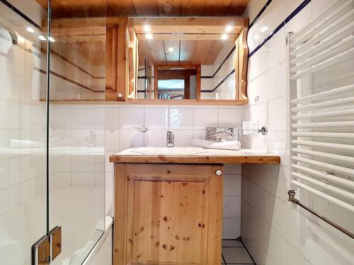 une salle de bain avec un lavabo, une baignoire et un miroir dans l'établissement Appartement 3P avec Balcon, Piscine et Parking · Proche Pistes à Reberty 2000 - FR-1-344-741, aux Menuires