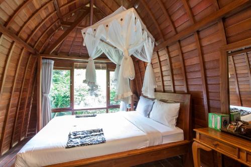 a bedroom with a bed in a wooden room at Bali Jungle Resort in Tegalalang