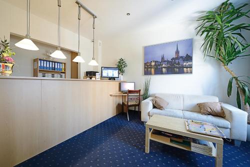 a living room filled with furniture and a tv at Baltic Hotel Lübeck in Lübeck