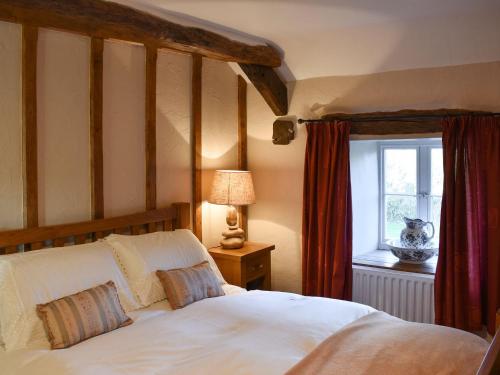 a bedroom with a white bed and a window at The Barracks in Little Strickland