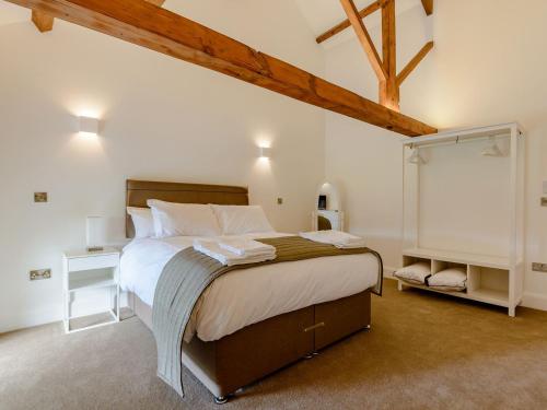 a bedroom with a large bed with white sheets at Church Manor in Carlton