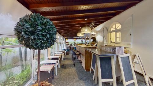 a restaurant with a bar with chairs and a plant at GREEN LORD DOMAINE - Lodges Piscine & Spa - Bar & Lounge - Restaurant gastronomique in Lamentin