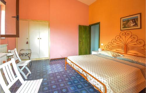 1 dormitorio con 1 cama con pared de color naranja en Gorgeous Home In Carano With Kitchen, en Carano