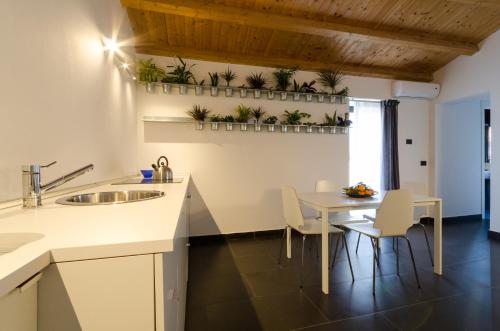a kitchen and dining room with a table and chairs at Pietranera Apartments in Catania