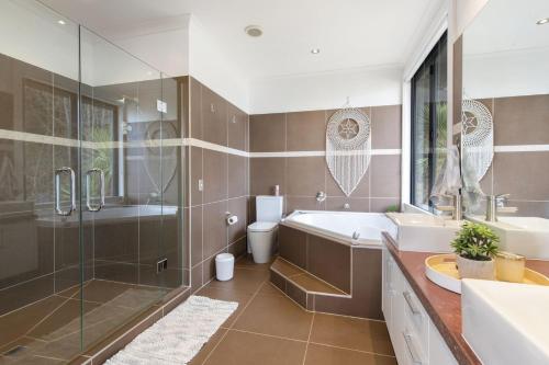 y baño con bañera, lavamanos y ducha. en Luxury Lake View Retreat with Hot Tub en Queenstown