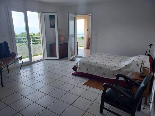 1 dormitorio con 1 cama y suelo de baldosa en grand studio en bas de villa avec vue sur mer au Carbet, en Le Carbet