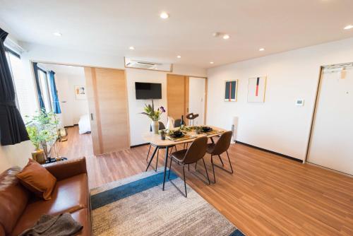 a living room with a table and chairs and a couch at TORA HOTEL Tokyo Skytree 寅ホテル スカイツリーF in Tokyo
