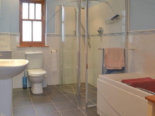 a bathroom with a toilet and a shower and a sink at Crofts in Badenyon