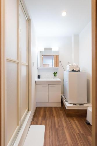 a white bathroom with a sink and a mirror at TORA HOTEL Tokyo Skytree 寅ホテル スカイツリーF in Tokyo