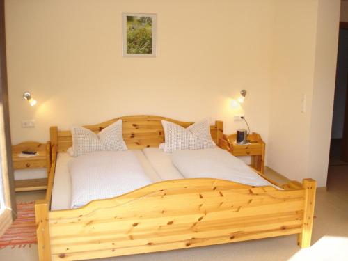 a wooden bed with white sheets and pillows in a room at Gasthof Zum Hohen Lohr in Battenhausen