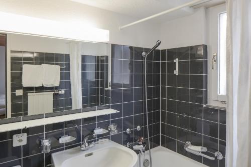 a bathroom with a sink and a mirror at Hotel Provisorium13 in Arosa