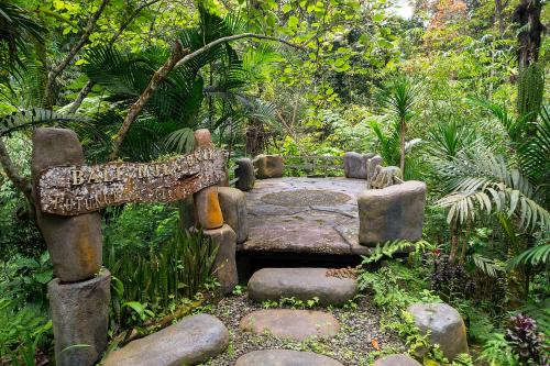 a garden with a stone bench and a sign at Bali Jungle Resort in Tegalalang