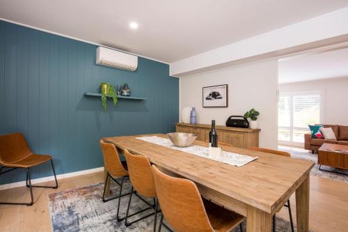 a dining room with a wooden table and chairs at Mirigaan I Pet Friendly I 8 Min Walk to Beach in Culburra Beach