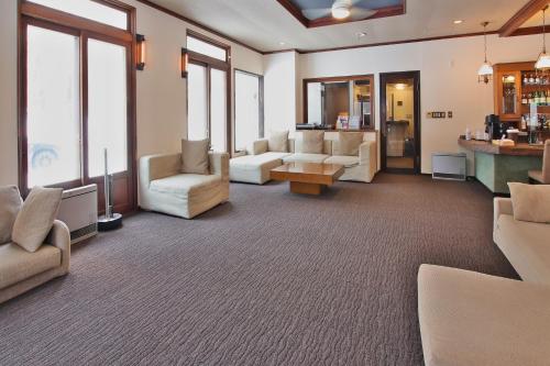 a waiting room with couches and tables and windows at Eternal Flame in Hakuba
