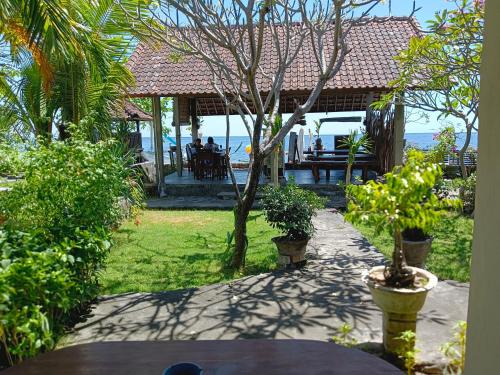 a garden with a gazebo with a table and plants at beach side Amed Delem family in Amed