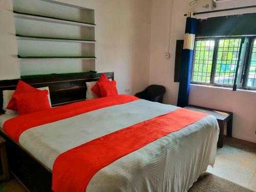 een slaapkamer met een groot bed met rode kussens bij Jim Corbett Home stay in Jhirna