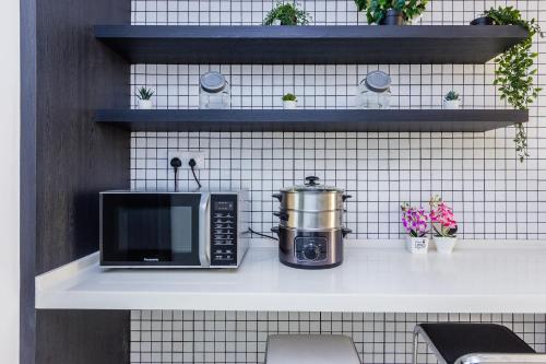 een keuken met een magnetron en een pot op een plank bij Z Hotel in Petaling Jaya