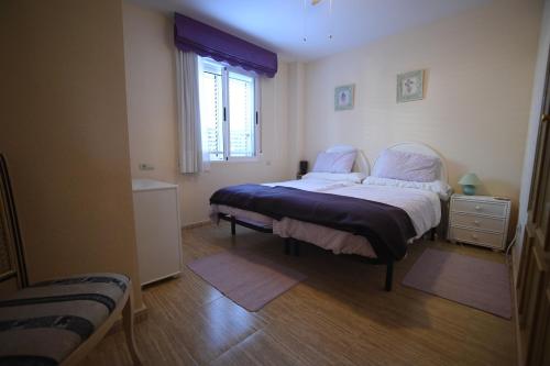 Un dormitorio con dos camas individuales y una ventana. en Jávea Golden Beach 1 Arenal Beach, en Jávea