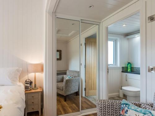 a bedroom with a glass door leading to a bathroom at Karelia Lodge in Kenmore