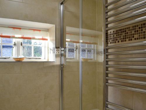 a shower with a glass door in a bathroom at The Mill in Tregaron
