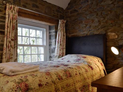 een slaapkamer met een bed voor een raam bij The Mill in Tregaron