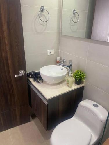 a bathroom with a white sink and a toilet at Turquesa - Exclusivo apartaestudio. (Nuevo) in Tunja