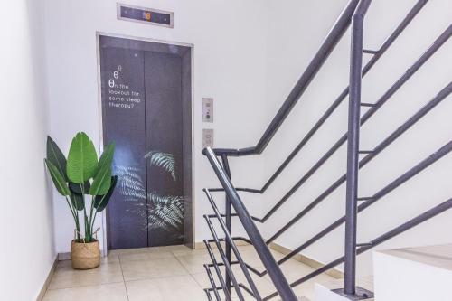 a staircase with a black door and a potted plant at Z Hotel in Petaling Jaya