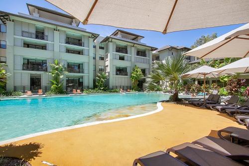 a swimming pool in front of a large building at Temple 2 Bedroom Penthouse in Palm Cove