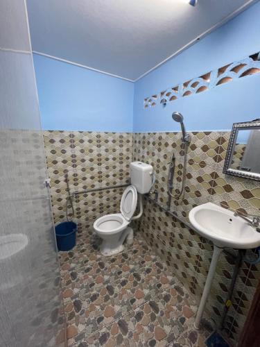 a bathroom with a toilet and a sink at Ikhlas Roomstay in Kampong Alor Gajah