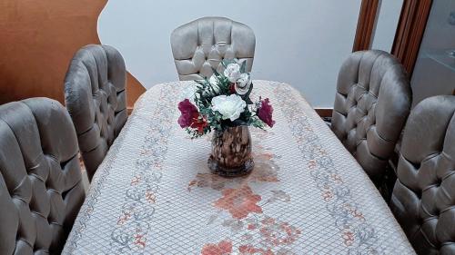 une table avec un vase de fleurs sur une table dans l'établissement Star House City Stars, au Caire