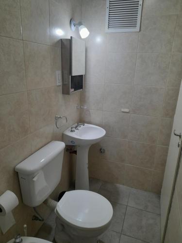 a bathroom with a toilet and a sink at Caseros Centro in San Juan