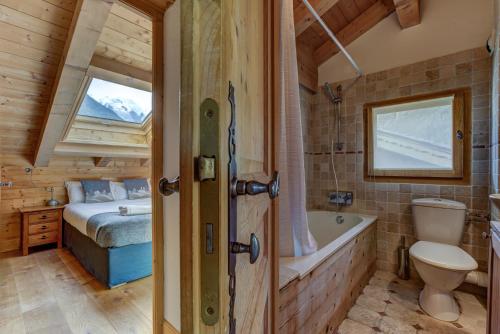 La Cloche des Bois - Alpes Travel - Les Bois - Sleeps 4-6 في شامونيه مون بلان: حمام به سرير وحوض استحمام وغرفة نوم