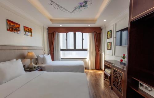 a hotel room with two beds and a window at Golden Legend Palace Hotel & Travel in Hanoi