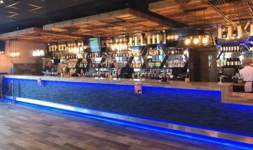 un bar con iluminación azul en un restaurante en Caravan on Golden Palm MV24 Chapel St Leonards en Chapel Saint Leonards