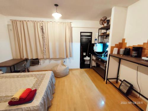 a bedroom with a bed and a desk and a window at Renovado departamento céntrico a mts de peatonal in Mendoza