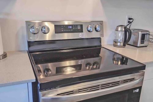 a stainless steel stove in a kitchen with a counter at NEWLY BUILT LUXURIOUS 3BRM TOWN HS/AIRPORT/PARKING in Brampton