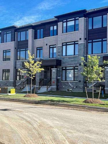 a large brick building with two trees in front of it at NEWLY BUILT LUXURIOUS 3BRM TOWN HS/AIRPORT/PARKING in Brampton