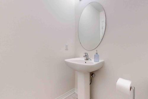 a white bathroom with a sink and a mirror at NEWLY BUILT LUXURIOUS 3BRM TOWN HS/AIRPORT/PARKING in Brampton