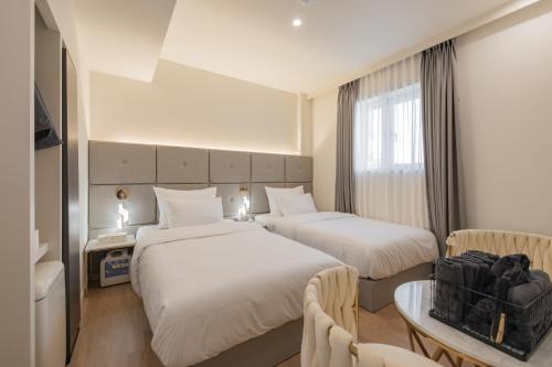 um quarto de hotel com duas camas e uma mesa em Denbasta Hotel Heritage em Gyeongju