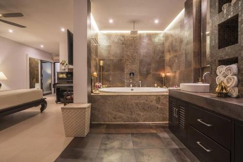 un ampio bagno con vasca e lavandino di Villa Nirvana - Beachfront Tropical Chic 4BR Haven in Cape Panwa, Phuket a Ban Ao Makham