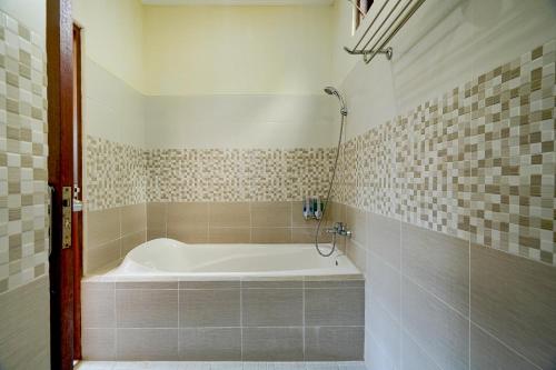 ein Bad mit einer Badewanne in einem Zimmer in der Unterkunft Queen Bisma Villa - 10 min walking to Ubud Center in Ubud