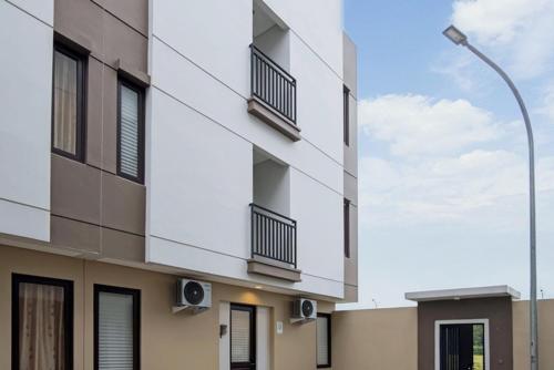 an apartment building with balconies and a street light at TwoSpaces Living at Zena Mozia in Tegal