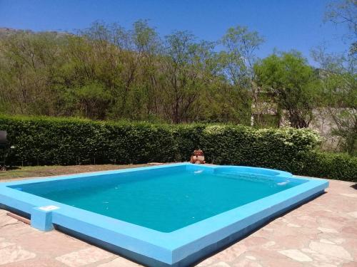 a person is sitting in a blue swimming pool at Cabaña La Raquela in La Paz