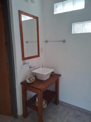 a bathroom with a sink and a mirror on a table at Cabaña La Raquela in La Paz