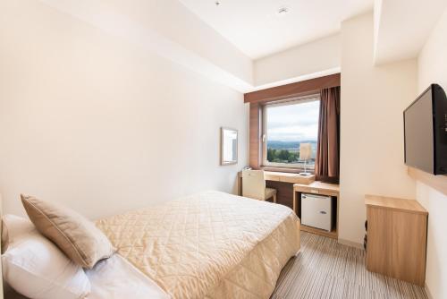 a hotel room with a bed and a television at UNIZO INN Kanazawa Hyakumangoku Dori in Kanazawa