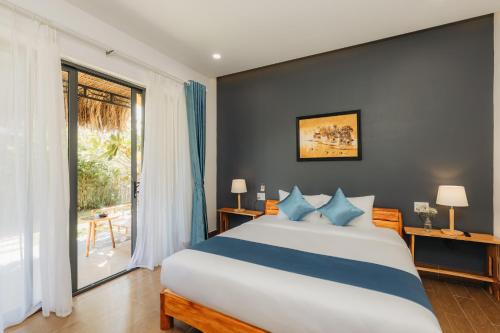 a bedroom with a large bed and a large window at Ngoc An Bang Villa in An Bang