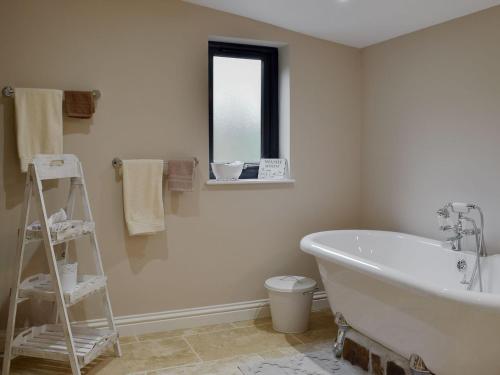 a bathroom with a white bath tub and a window at Castle Farm - Uk10563 in Henrys Moat