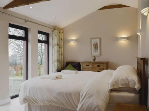 a bedroom with a large white bed and a window at Castle Farm - Uk10563 in Henrys Moat