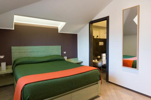 a bedroom with a green bed and a mirror at Palazzo Di Donato in Cava deʼ Tirreni